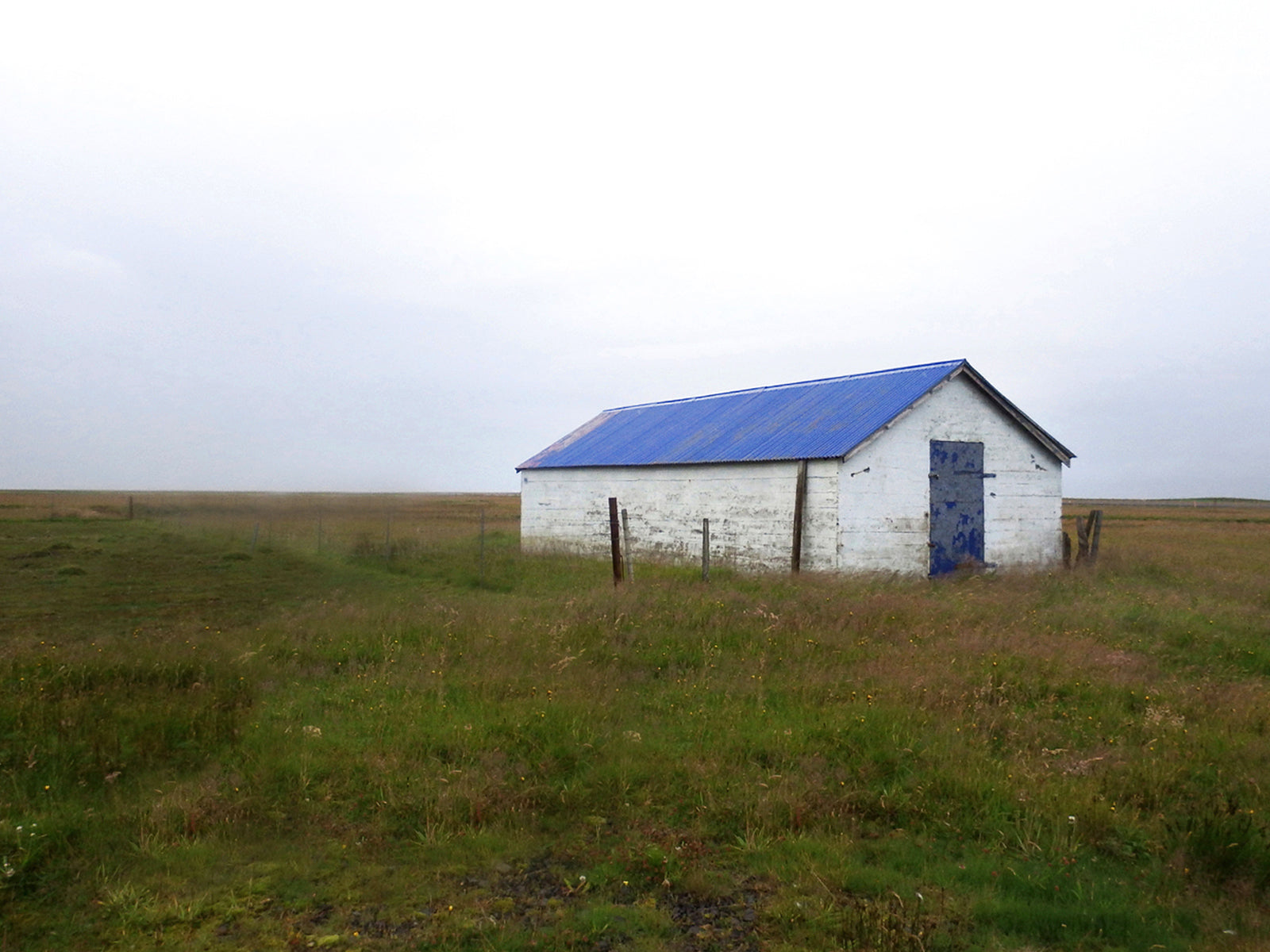 Old, concrete barn with a blue roof in Iceland.  Fine Art Photography. Kristen Olivares