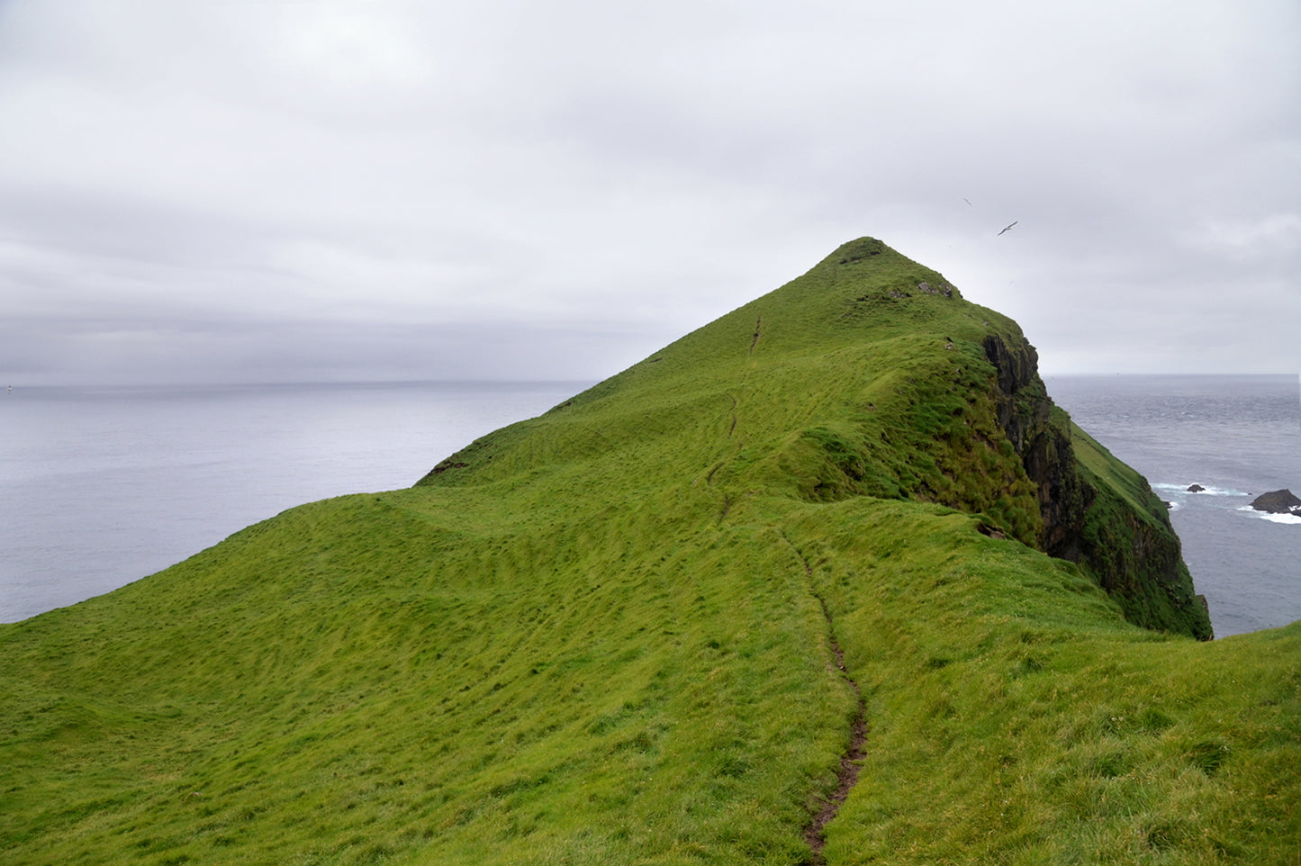 A stunning image of a cliff jetting out into the Atlantic Ocean in the Faroe Islands. Fine art photography by Kristen Olivares.