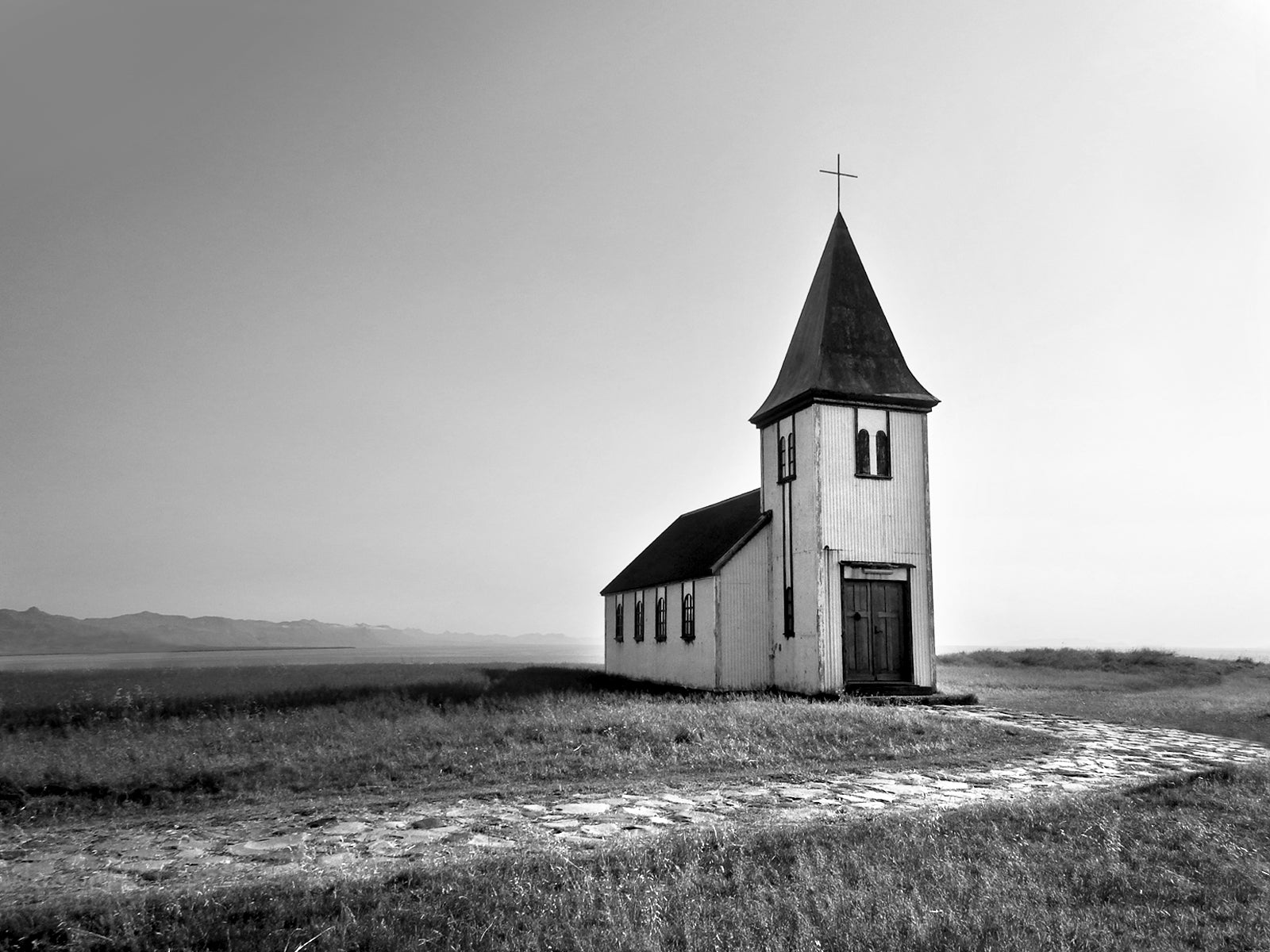 A beautiful church set out in a quiet setting in Iceland. Black and white photo. Canvas wall art by Kristen Oliavres