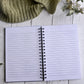 Opened hardcover journal, showing lined pages. 200 pages, spiral bound. 