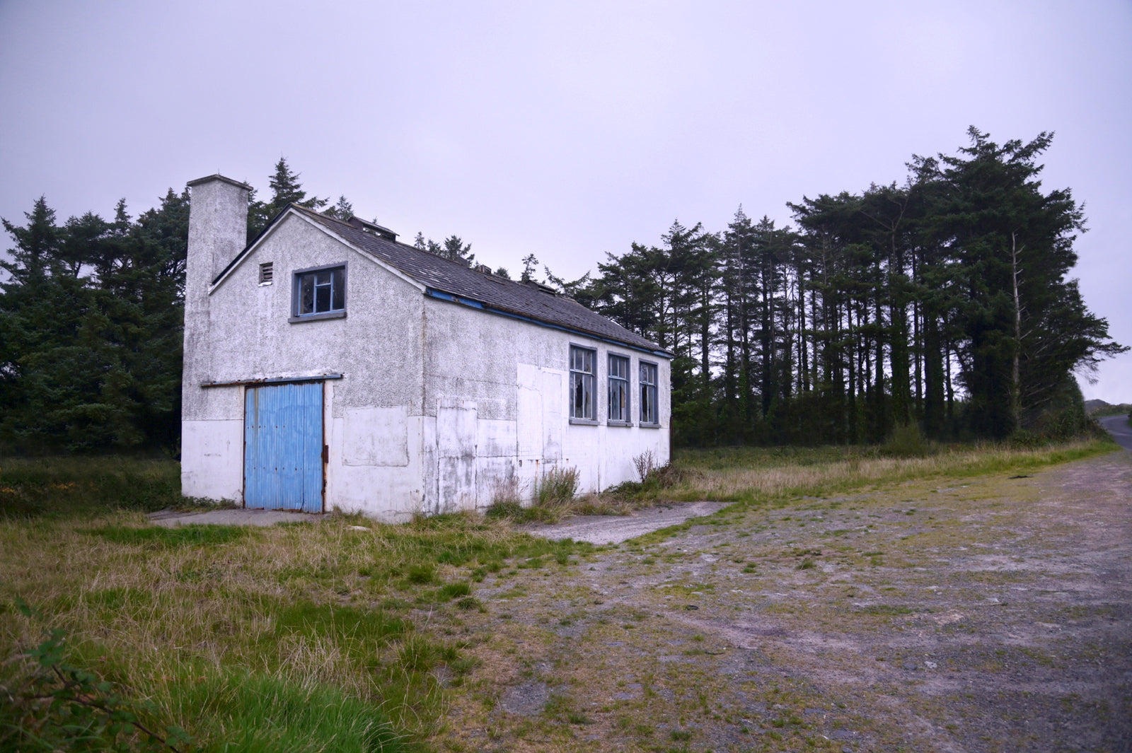 A photo of a stone white house in Ireland with a blue door. Framed canvas print by Kristen Olivares.