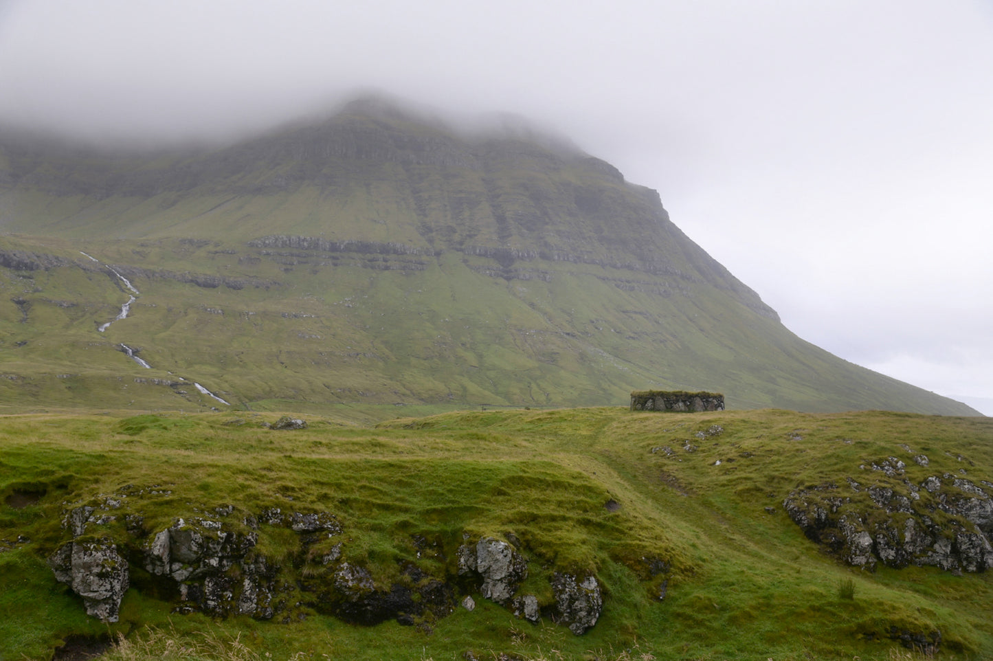 Beautiful old stone shack used to a sheep shelter in the foggy lands of the Faroe Islands. Framed fine art photography by Kristen Olivares