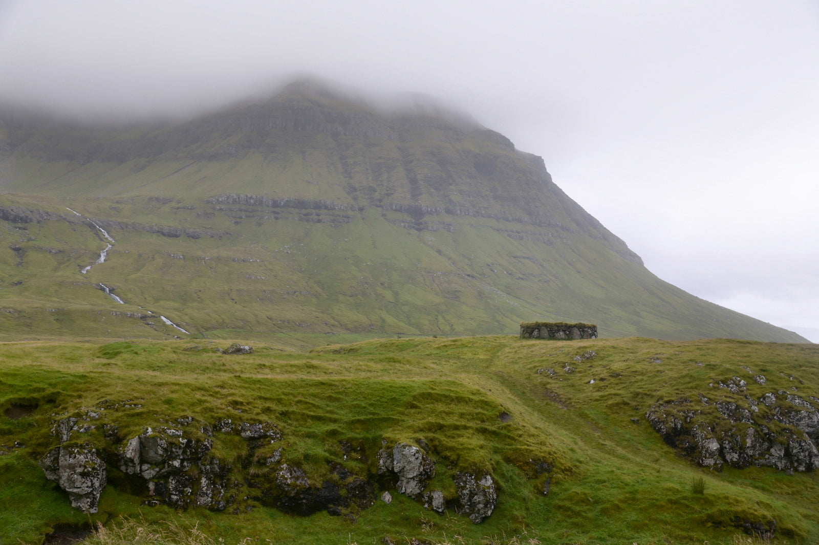 Beautiful old stone shack used to a sheep shelter in the foggy lands of the Faroe Islands. Framed fine art photography by Kristen Olivares