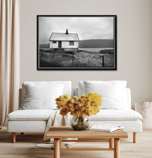 Black and white image of an old house tucked away in the Faroe Islands. Framed fine art photography by Kristen Olivares