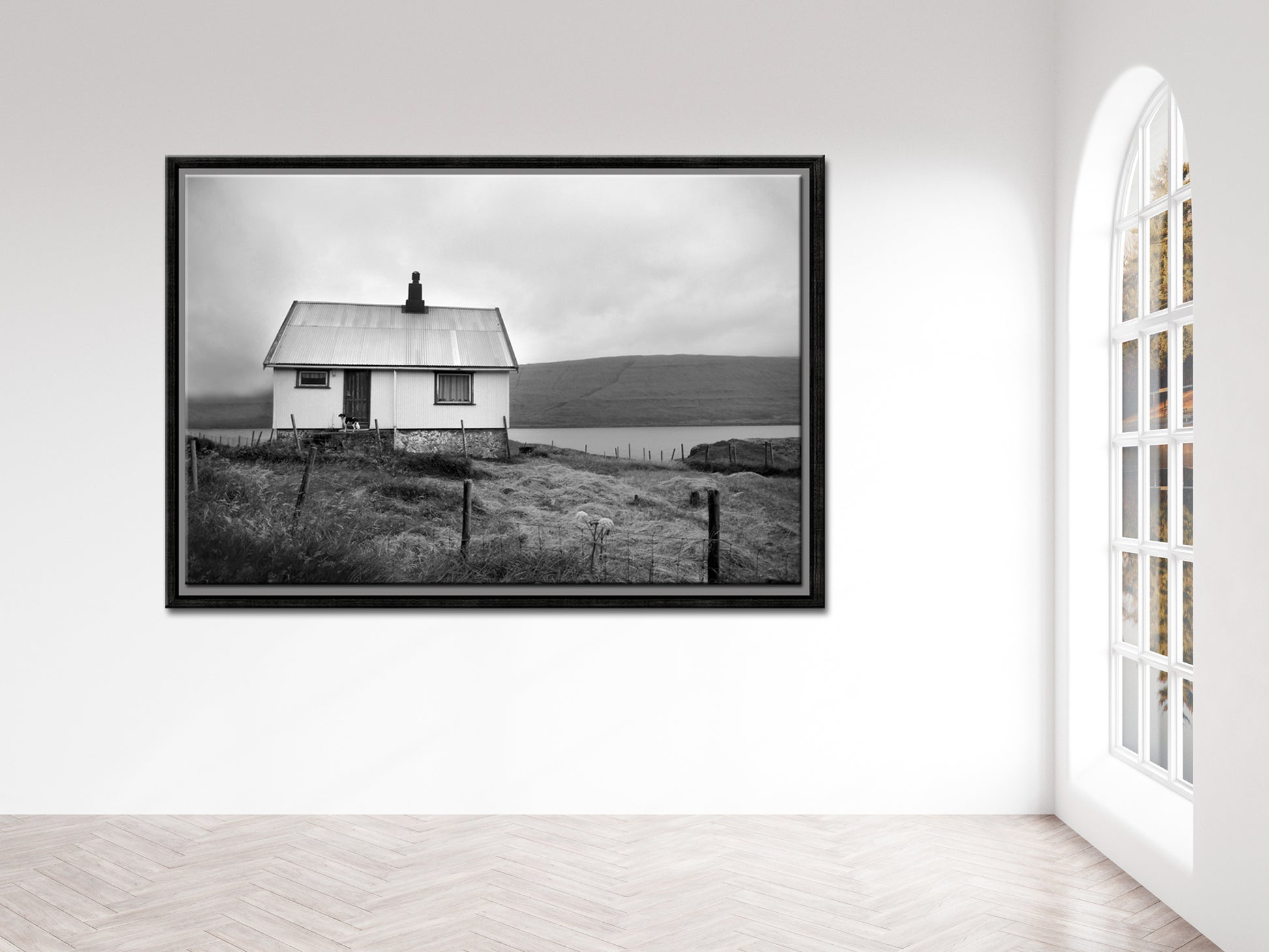 Black and white image of an old house tucked away in the Faroe Islands. Framed fine art photography by Kristen Olivares