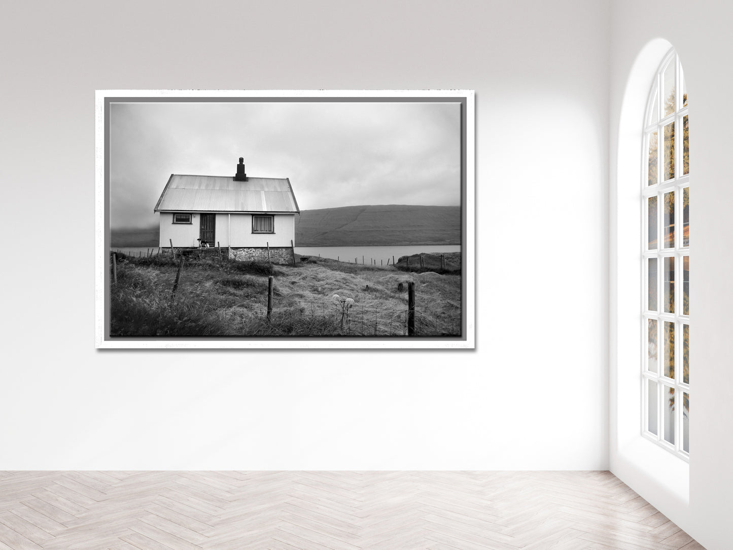 Black and white image of an old house tucked away in the Faroe Islands. Framed fine art photography by Kristen Olivares
